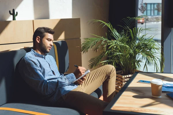 Uomo che scrive nel taccuino — Foto stock