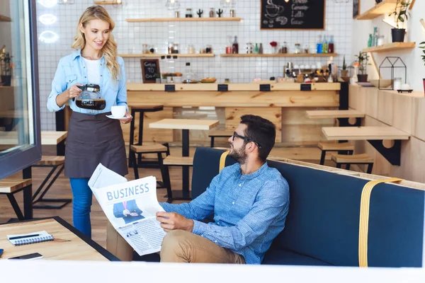 Waitress pouring coffee to client — Stock Photo