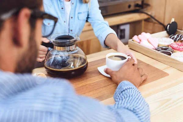 Waitress pouring coffee to client — Stock Photo