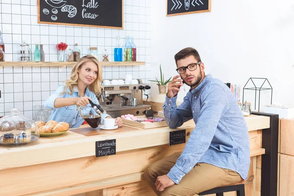 Waitress pouring coffee to client — Stock Photo