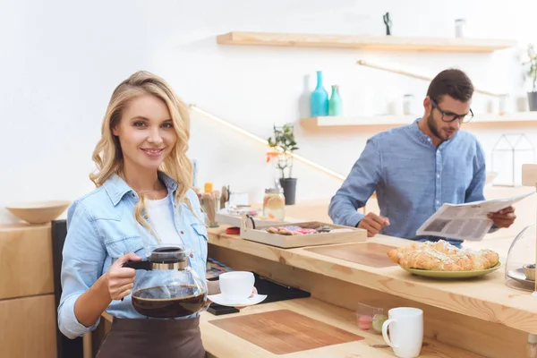 Kellnerin mit Kaffeekanne und Tasse — Stockfoto