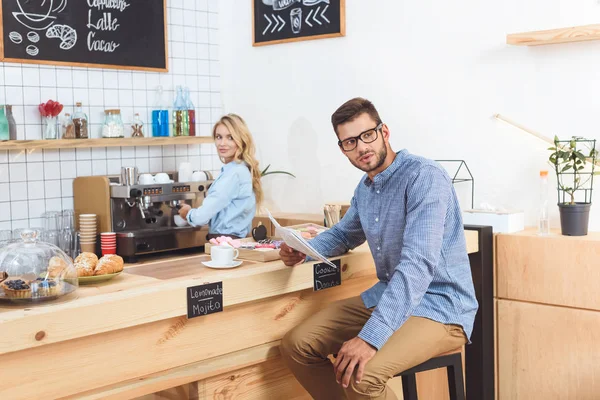 Uomo che legge giornale in caffè — Foto stock