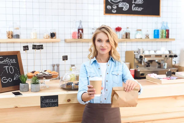 Waitress holding coffee to go — Stock Photo