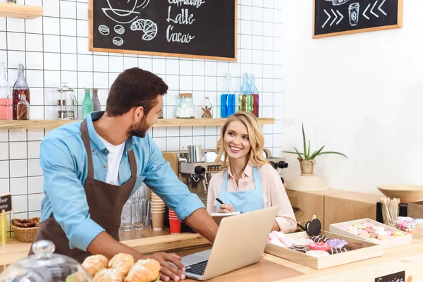 Cafe owners using laptop — Stock Photo