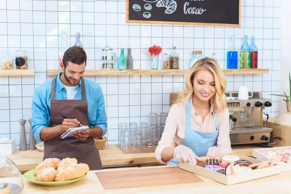 Pareja trabajando juntos en la cafetería - foto de stock