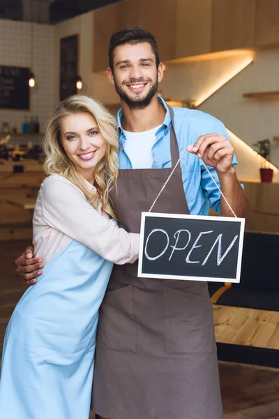 Cafe owners with sign open — Stock Photo