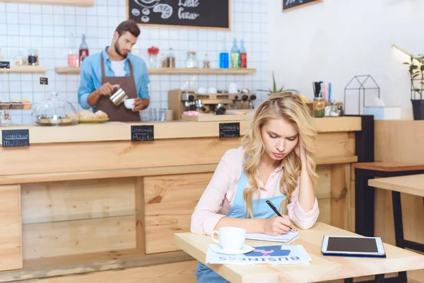 Propietario de la cafetería tomando notas - foto de stock