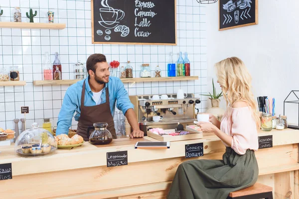 Barista y cliente en la cafetería - foto de stock