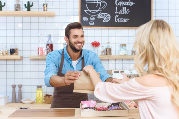 Camarero regalando comida para llevar al cliente — Stock Photo