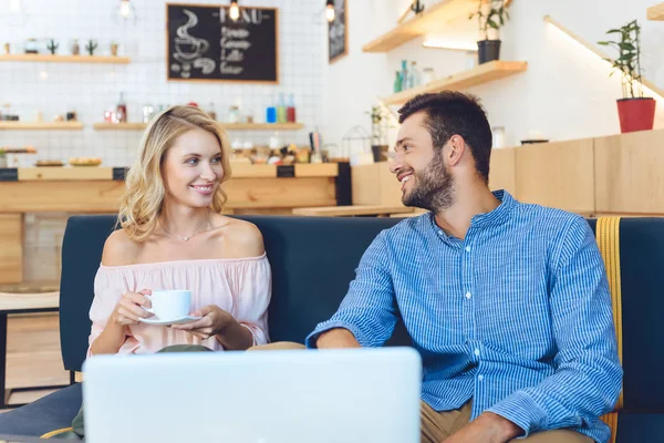 Couple en utilisant un ordinateur portable dans le café — Photo de stock