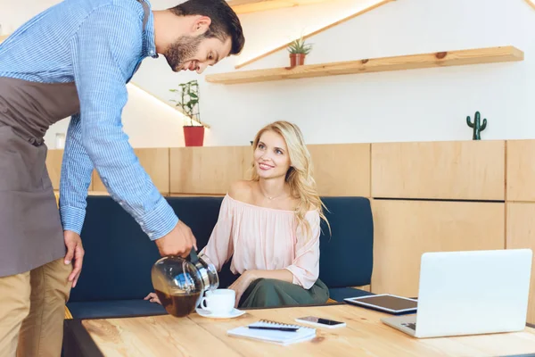 Waiter pouring coffee to client — Stock Photo