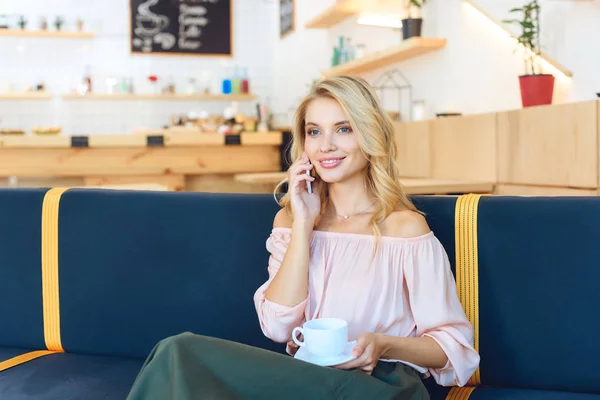 Mujer con café hablando en smartphone - foto de stock