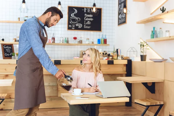 Waiter pouring coffee to client — Stock Photo