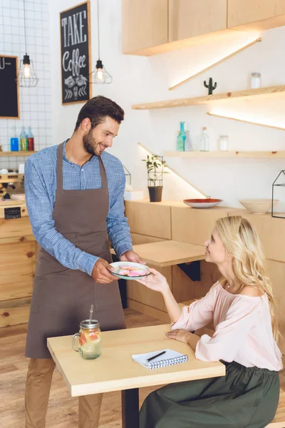 Waiter giving cookies to client — Stock Photo