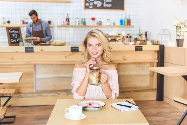 Mujer bebiendo limonada en la cafetería - foto de stock