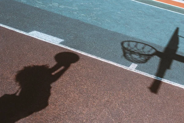 Sombra de mujer lanzando pelota - foto de stock