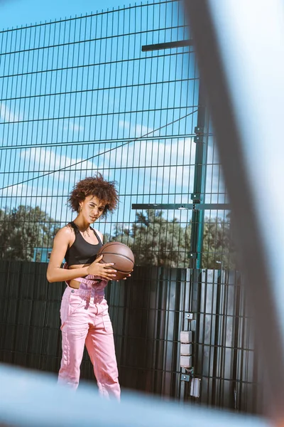 Mujer afroamericana sosteniendo baloncesto - foto de stock