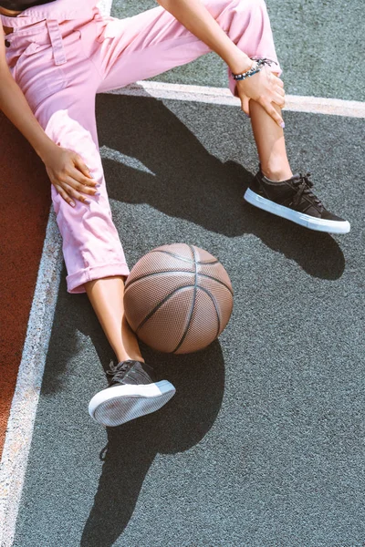 Баскетбол возле женской ноги — стоковое фото