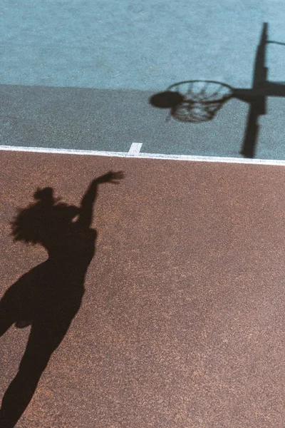 Sombra de mujer lanzando pelota - foto de stock