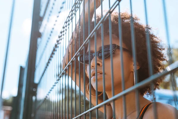 Donna afro-americana dietro recinzione cablata — Foto stock