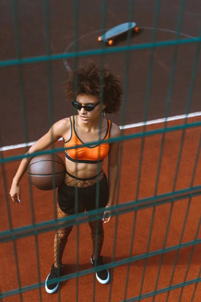 Mujer afroamericana sosteniendo baloncesto - foto de stock