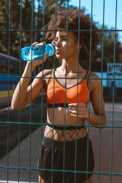 Adatta donna afro-americana che beve acqua — Foto stock