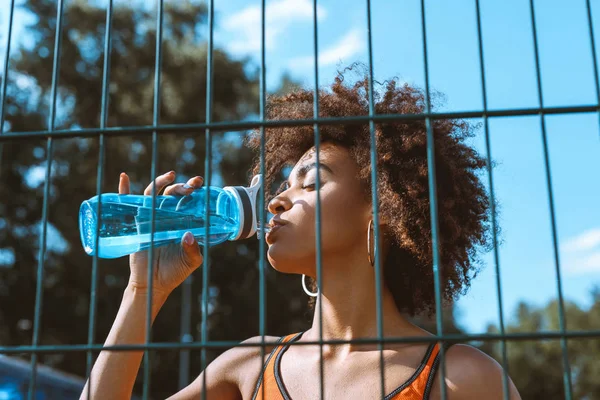 Fit african-american woman drinking water — Stock Photo