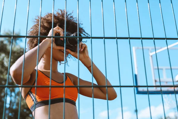 Mujer deportiva tomando fotos con la cámara - foto de stock