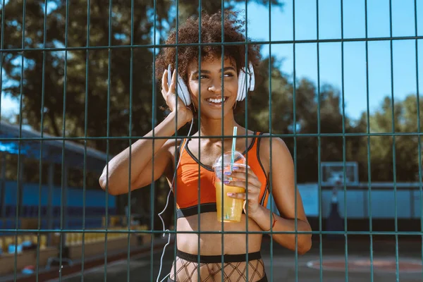 Mujer afroamericana escuchando música en auriculares - foto de stock
