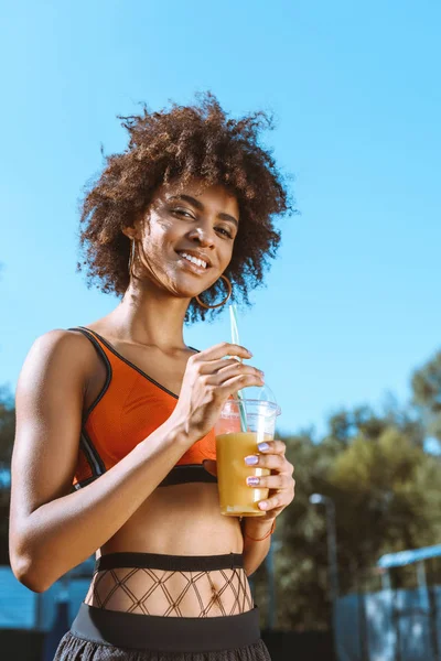 Fit african-american woman drinking juice — Stock Photo