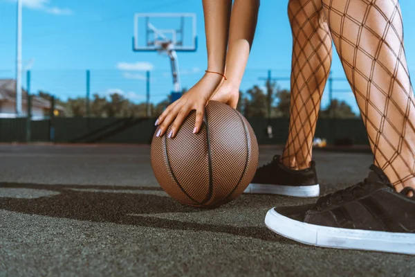 Frau legt Basketball auf den Boden — Stockfoto