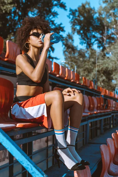 Спортсменка афроамериканка п'є воду — стокове фото