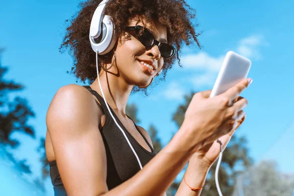 Mujer afroamericana deportiva en auriculares - foto de stock