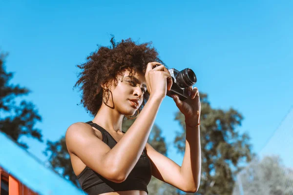 Athletic african-american woman with camera — Stock Photo