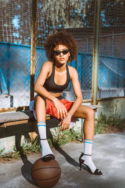 Mujer afroamericana en ropa deportiva y tacones altos - foto de stock