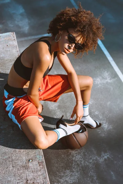 Mujer afroamericana en ropa deportiva y tacones altos - foto de stock