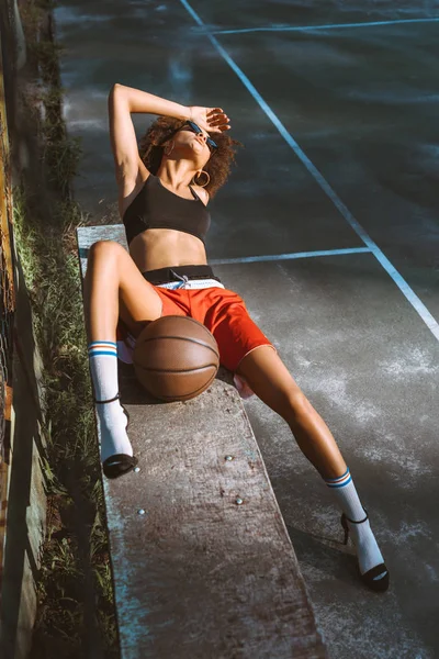 Woman in sportswear and heels on bench — Stock Photo