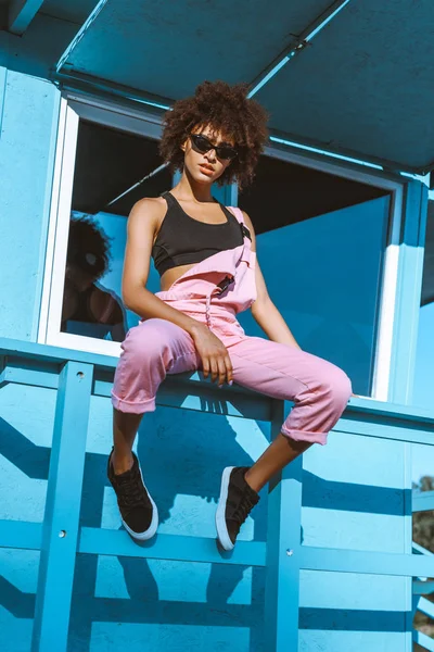 African-american woman in sports bra and overalls — Stock Photo