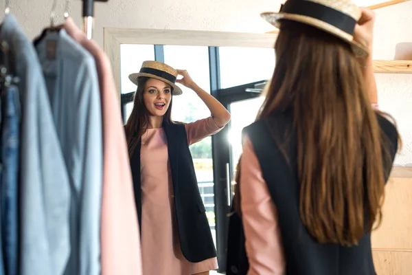 Chica probándose el sombrero en boutique - foto de stock