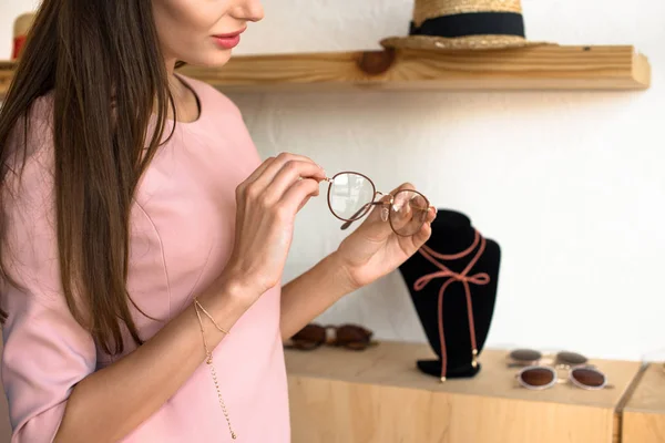 Chica la elección de gafas en boutique - foto de stock