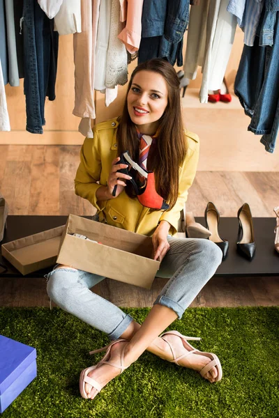 Mujer joven eligiendo zapatos - foto de stock