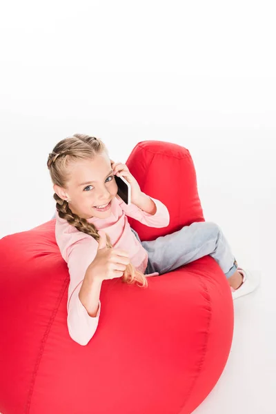 Child with thumb up and smartphone — Stock Photo