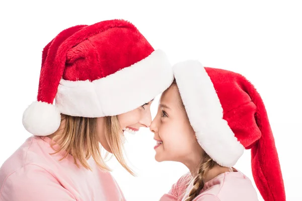 Madre e hija en sombreros de santa - foto de stock