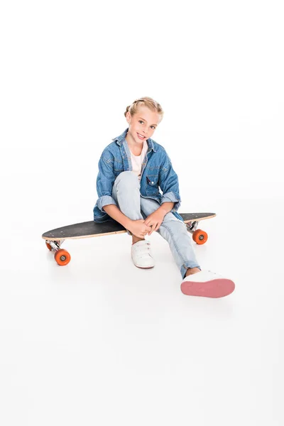 Little skateboarder sitting on longboard — Stock Photo