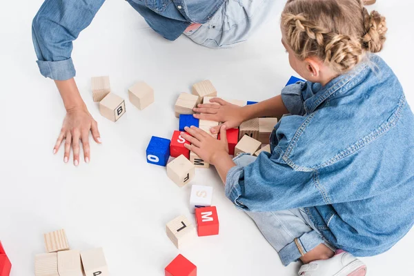 Madre e hija jugando con bloques de abecedario - foto de stock