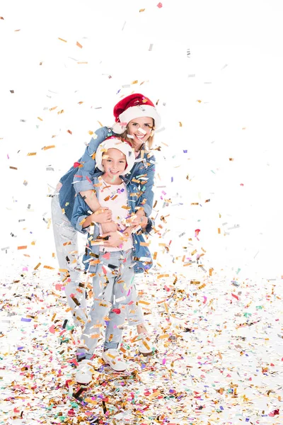 Madre e hija con confeti en Navidad - foto de stock