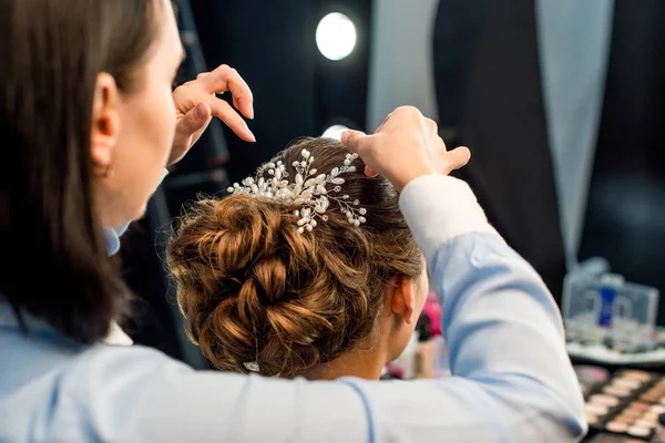 Hairstylist decorating clients hairstyle — Stock Photo