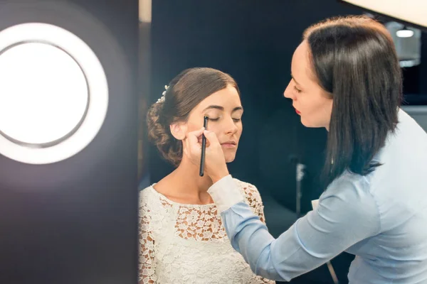 Maquiagem artista aplicando sombras oculares — Fotografia de Stock