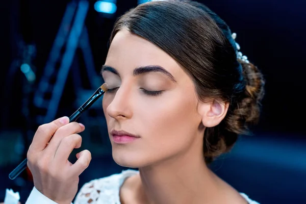 Maquillaje artista aplicando sombras de ojos - foto de stock