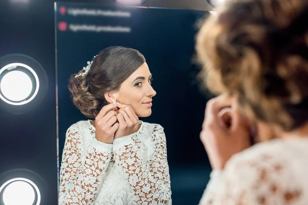 Frau trägt Ohrringe — Stockfoto